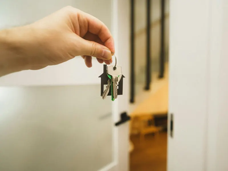Keys to a new home, held at the front door